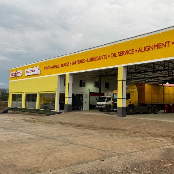 A yellow building with a yellow truck in front of it AI-generated content may be incorrect_